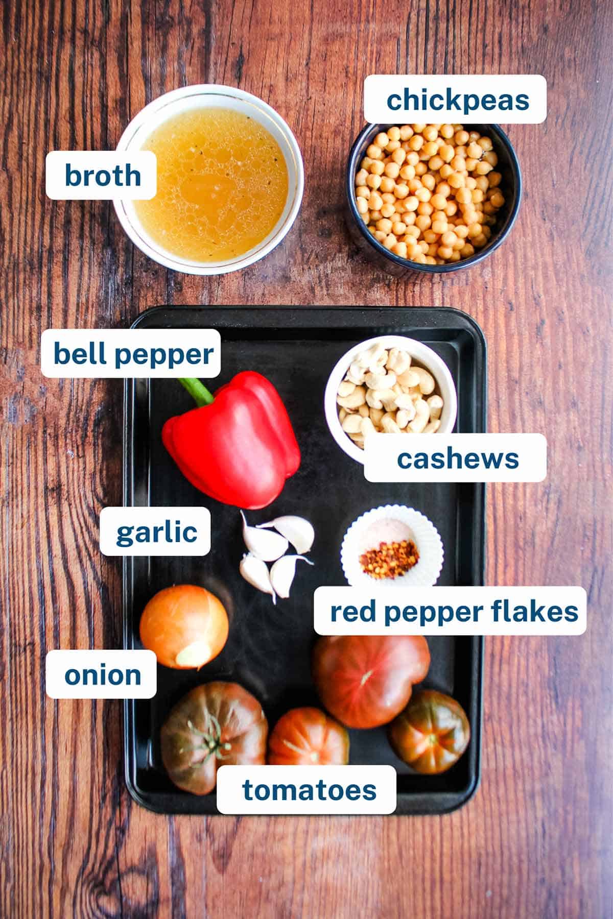 Ingredients to make tomato and chickpea soup on the table with text labels.