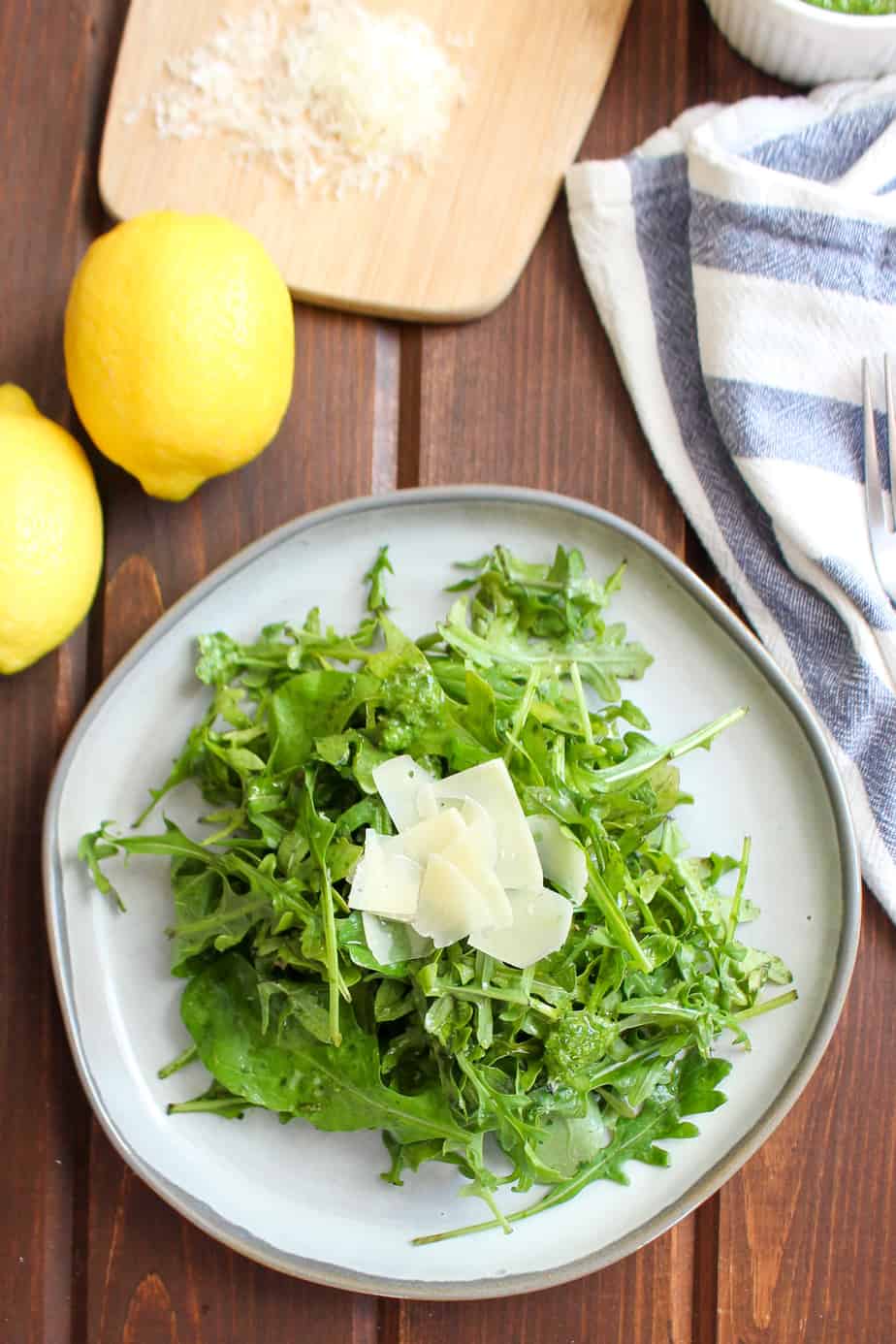 plated arugula tossed in dressing with parmesan on top