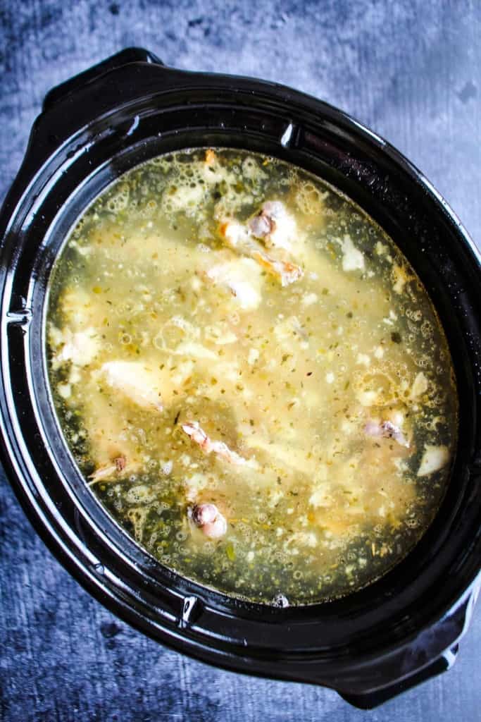 Cooked chicken bone broth in the slow cooker.