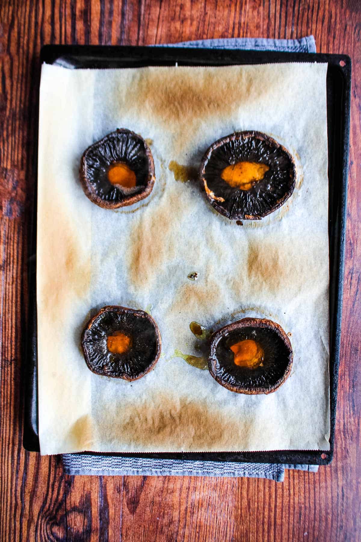 Mushroom caps on a baking tray after cooking.