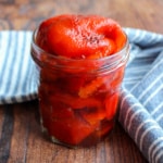 Clear jar overfilled with roasted red peppers