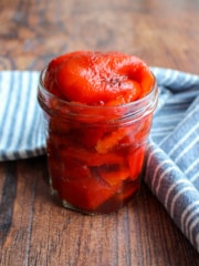 Clear jar overfilled with roasted red peppers