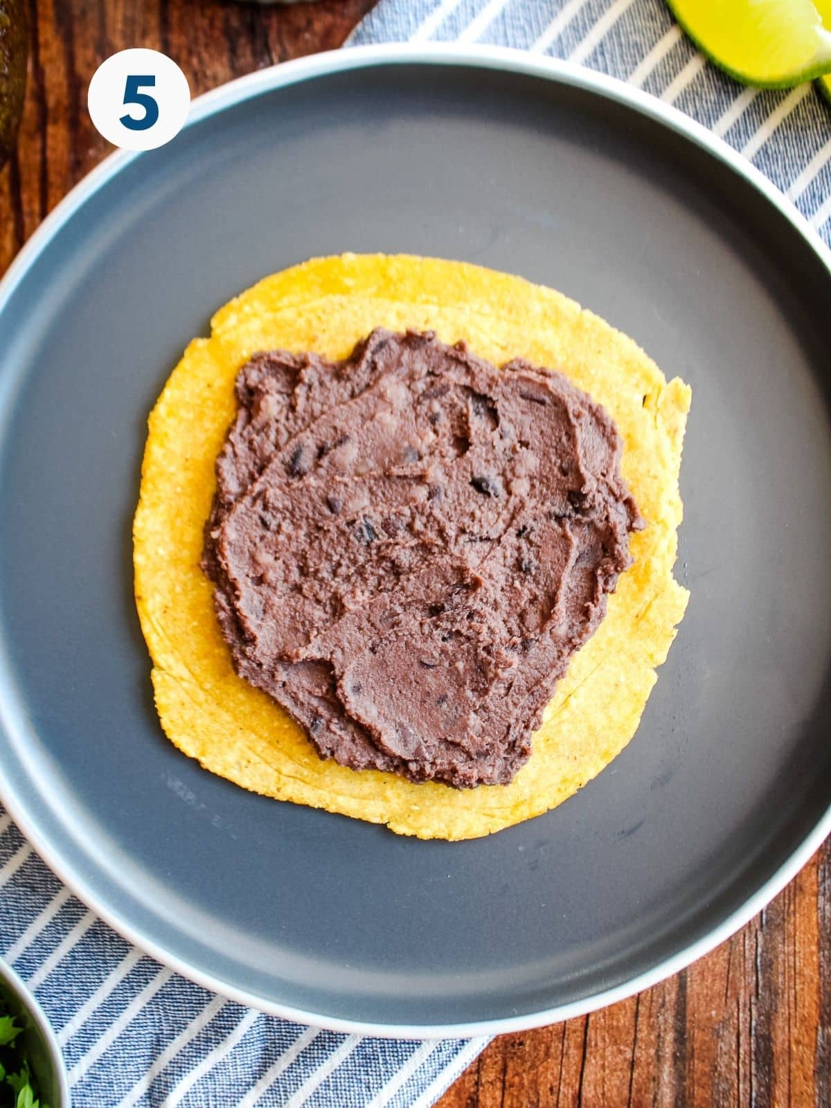 Black beans spread on a tortilla.