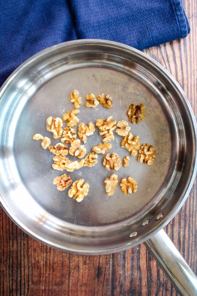 Toasting the walnuts in a skillet.