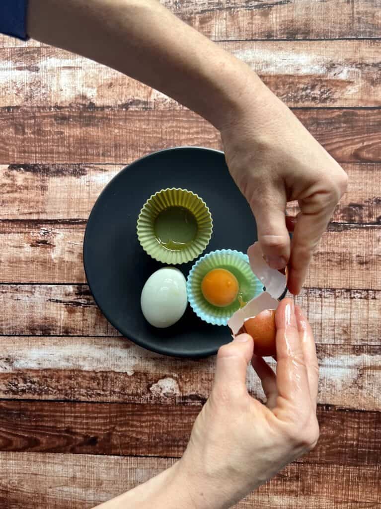 Cracking eggs into silicone muffin liners to make poached eggs