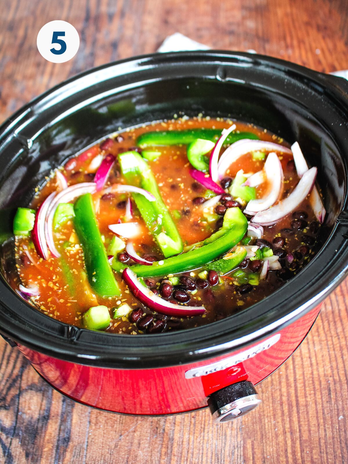 Everything added to the slow cooker to make chicken burrito bowls.