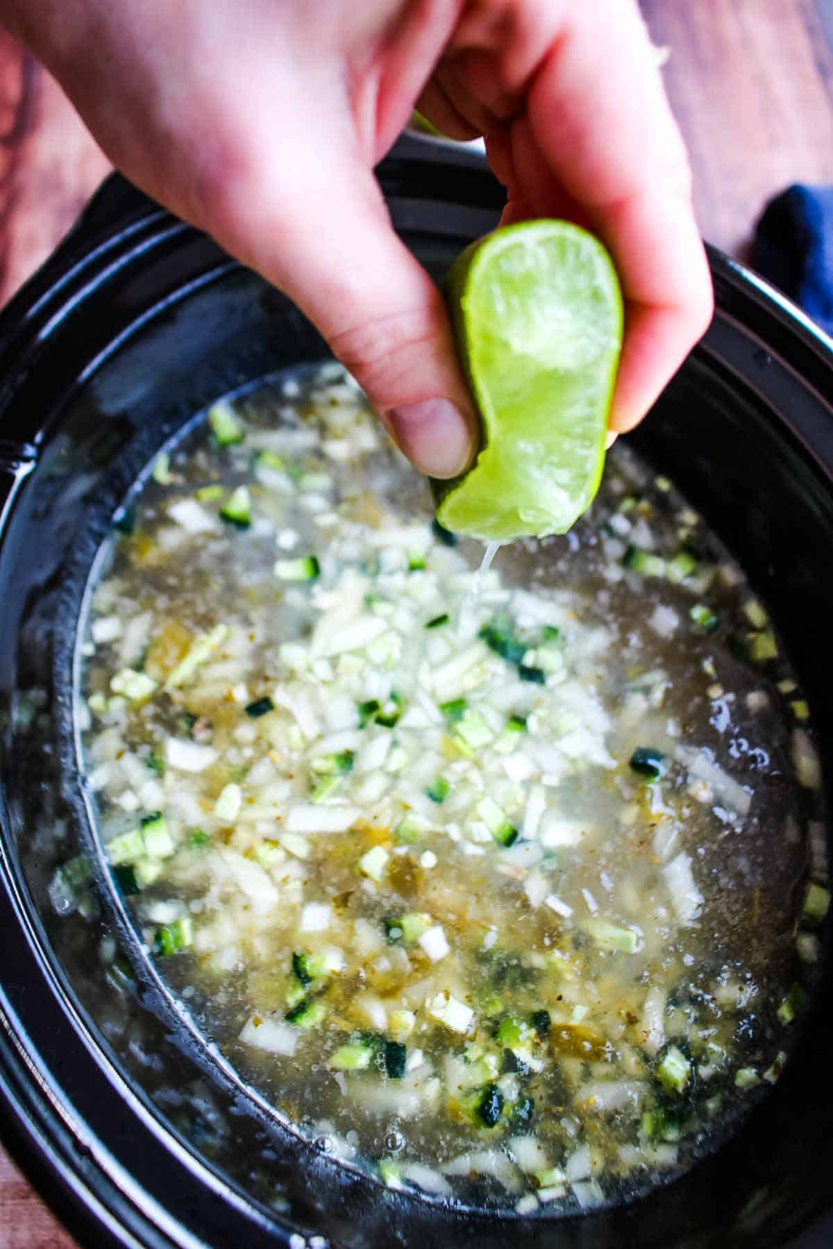 Squeezing lime juice into the slow cooker.
