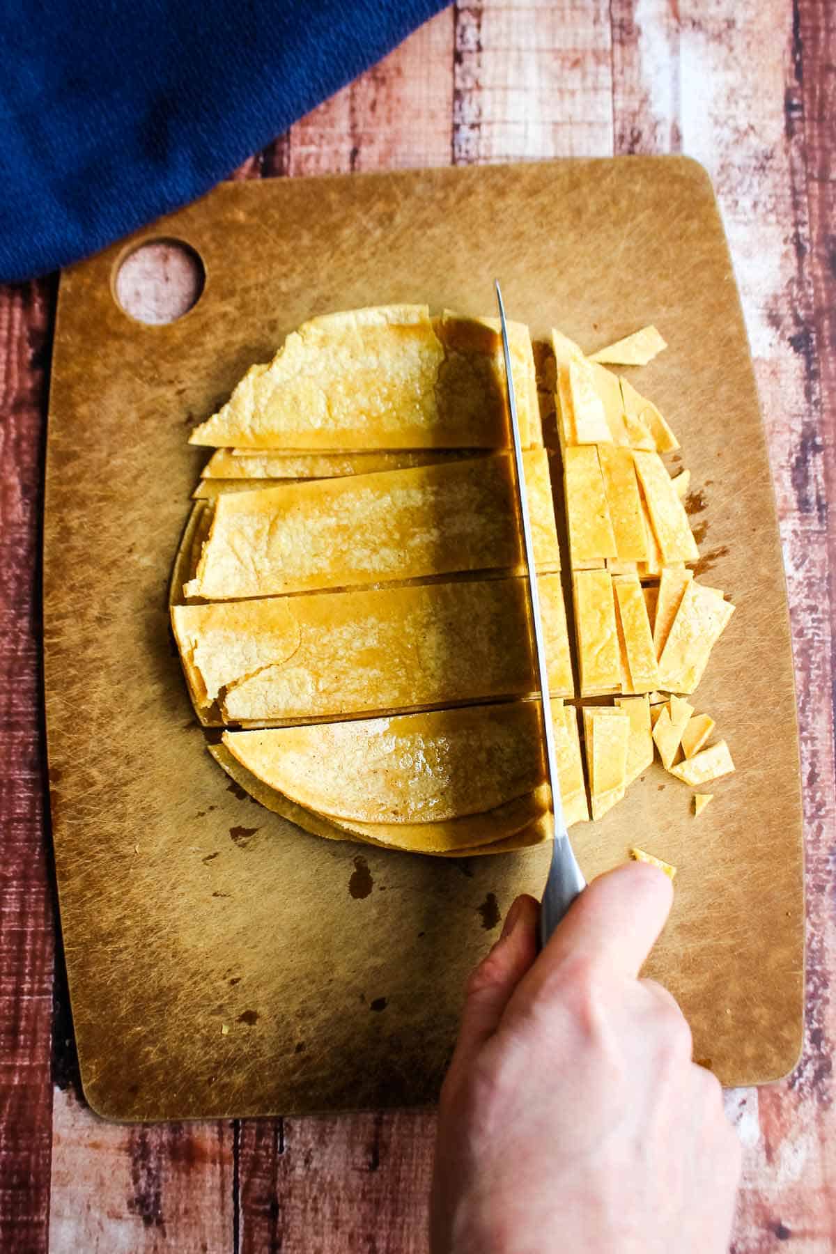 Cutting the tortillas on a cutting board.