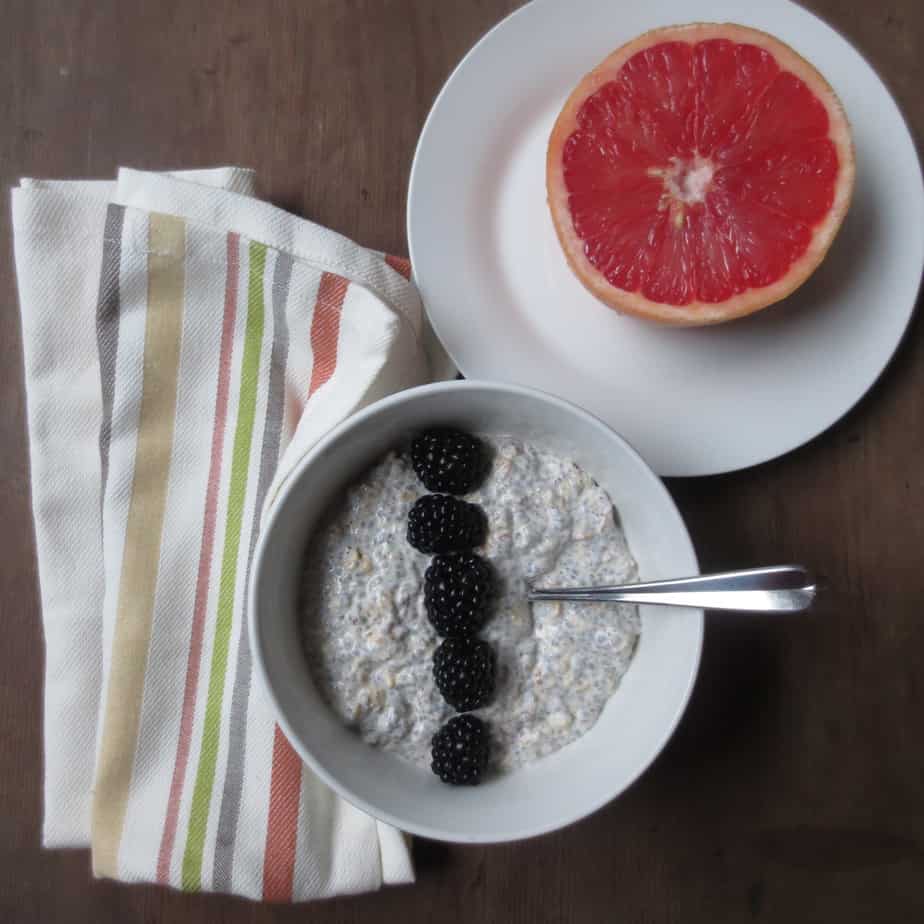 overnight chia seed oatmeal with blackberries on top and a grapefruit on the side