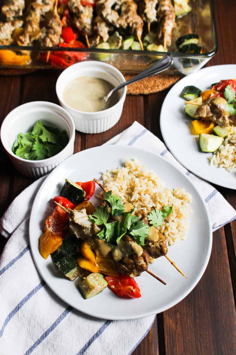 spread of chicken satay with colorful bell peppers and zucchini