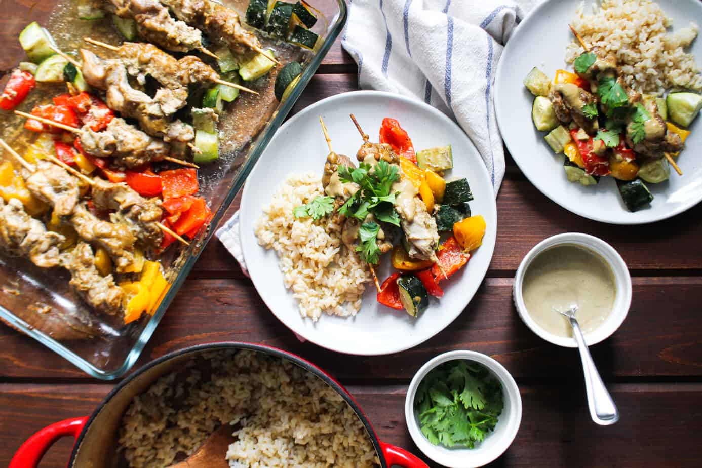 spread of chicken satay with colorful bell peppers and zucchini