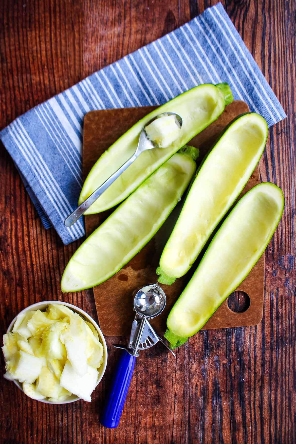 Zucchini b.oat halves on the table with the insides scooped out