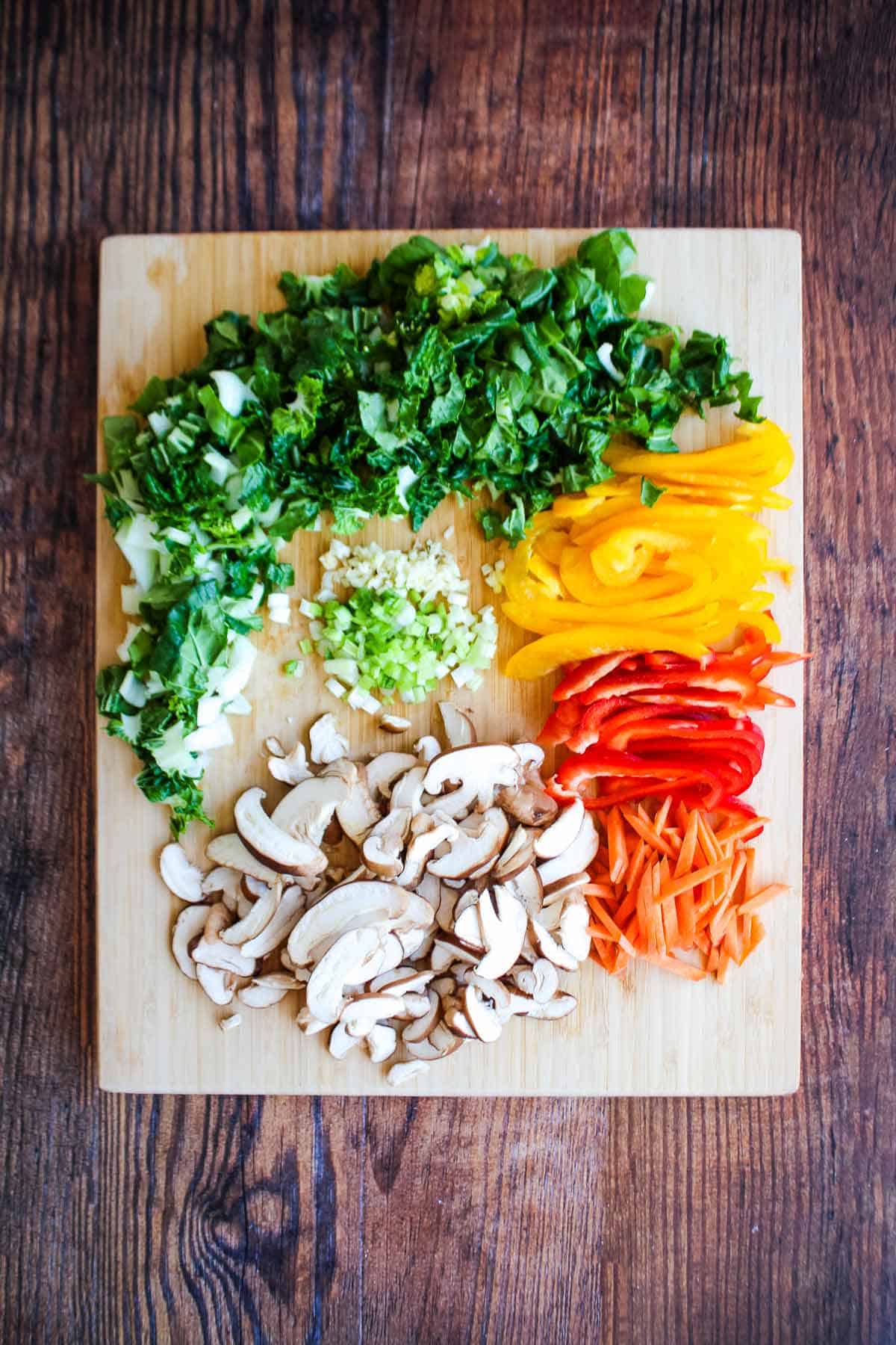 Veggies for peanut noodles chopped on a cutting board.