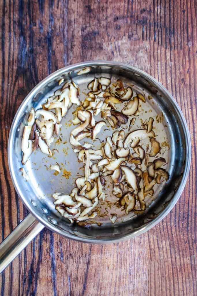 Mushrooms cooking in a skillet.