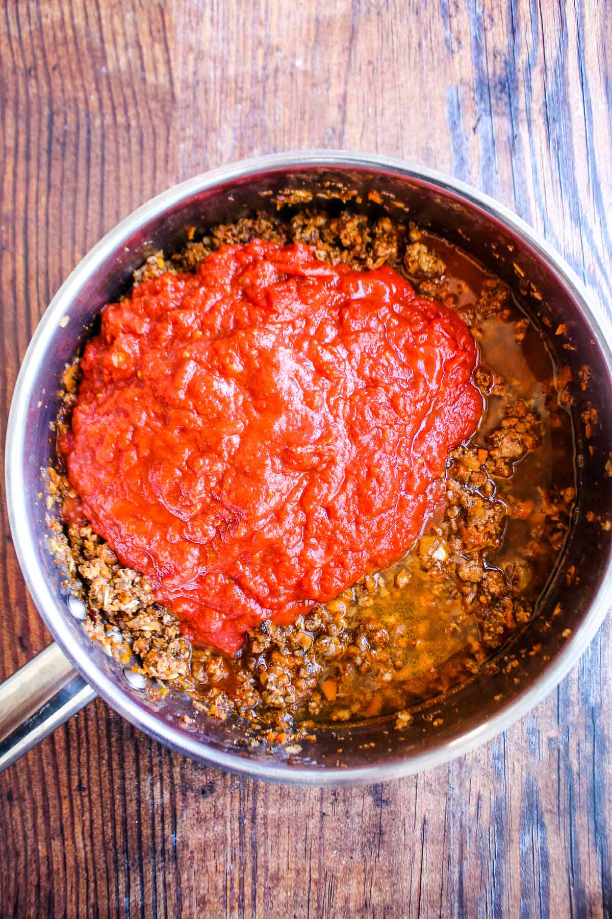 Tomatoes added to the pan of cooked sausage.