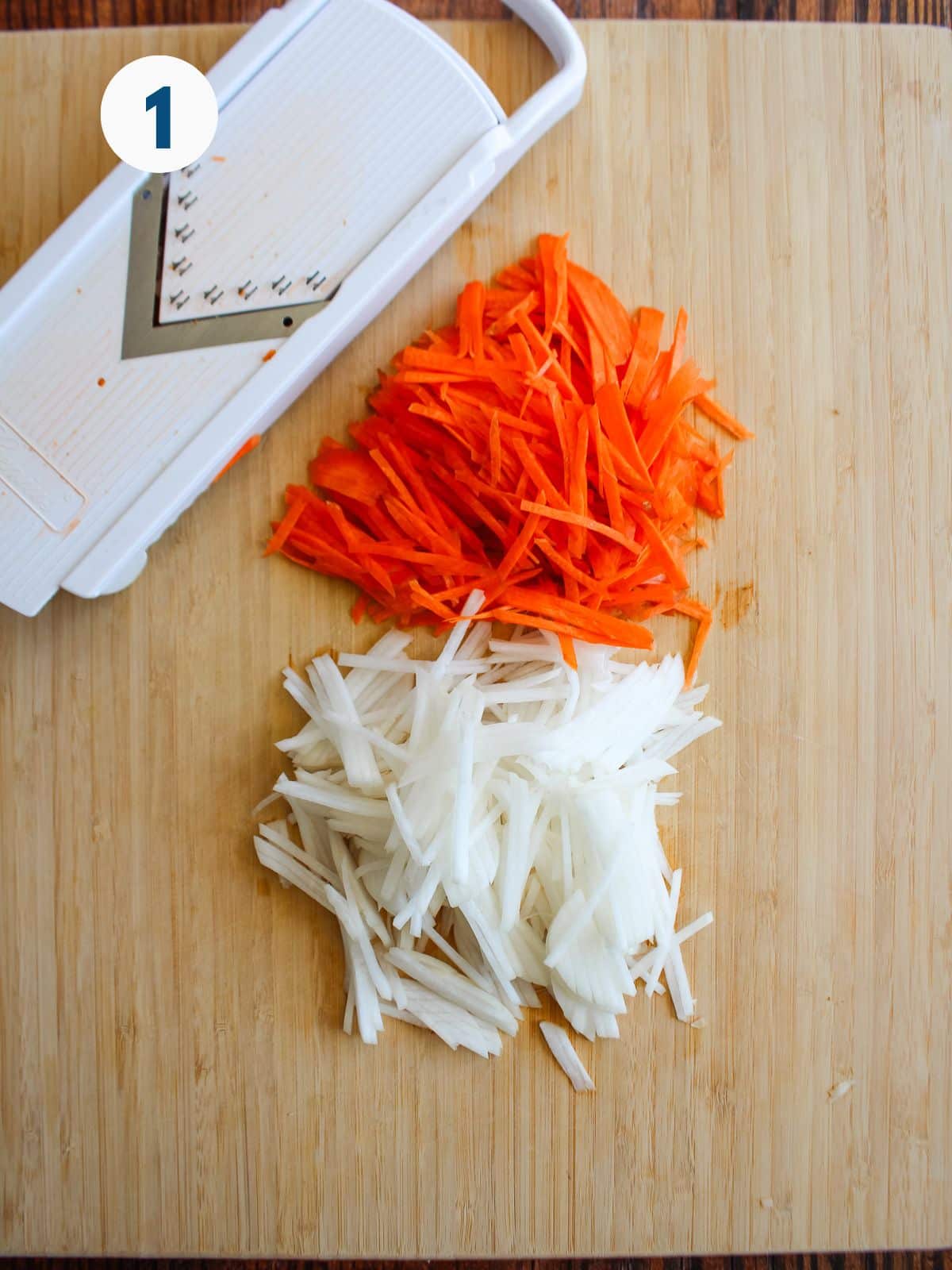 Carrots and radish on a cutting board with a mandolin off to the side.