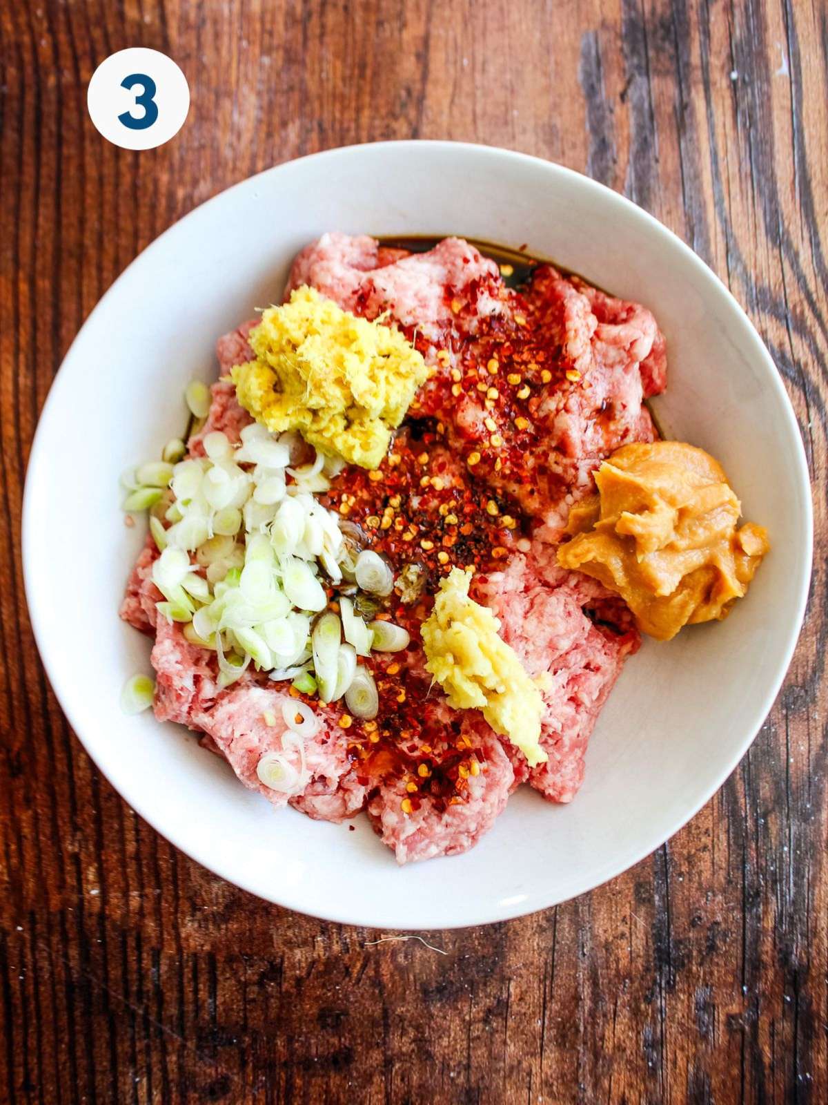 Ground pork and seasoning in a bowl.