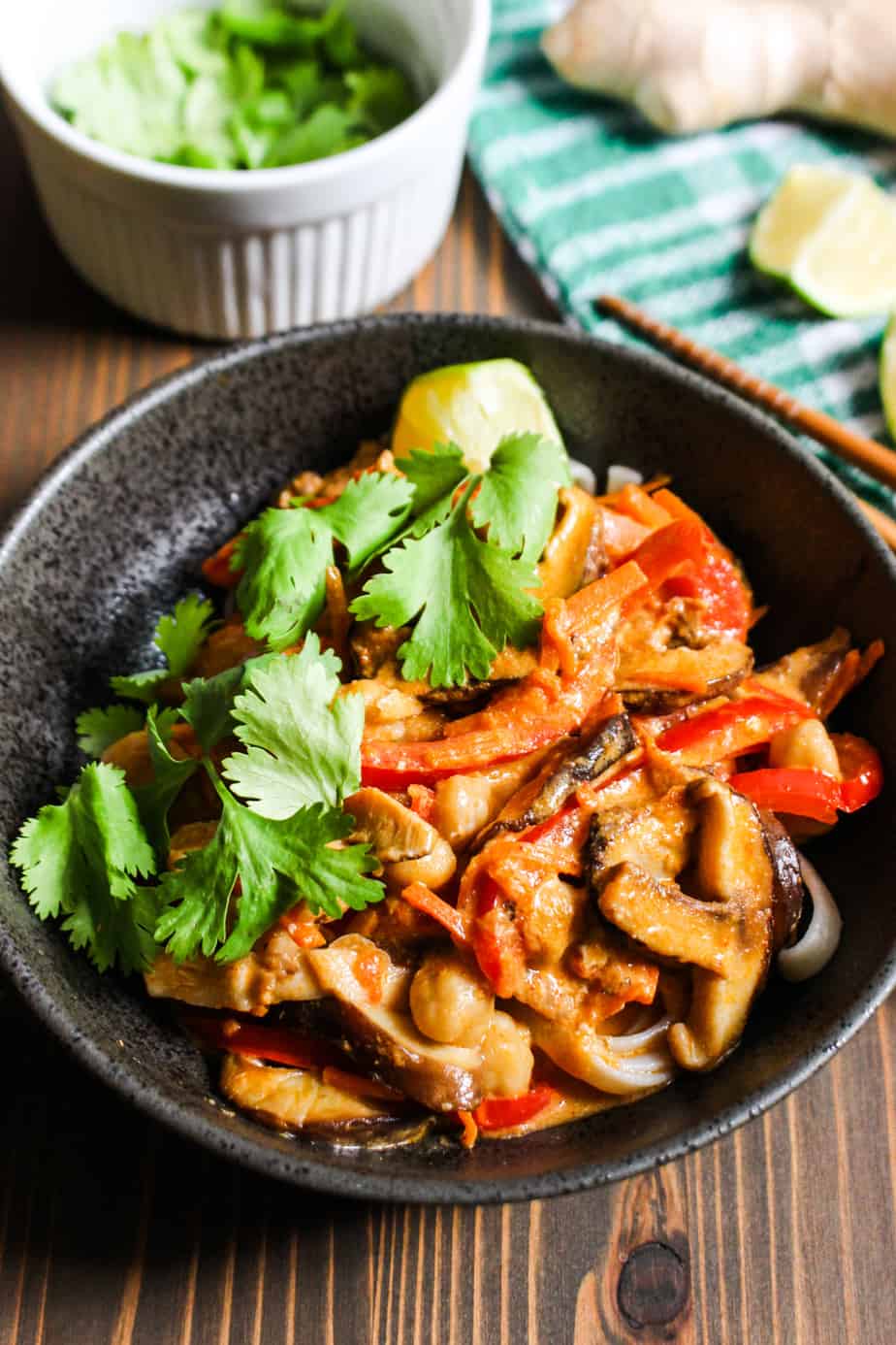 bowl of thai red curry soup with bell peppers and mushrooms