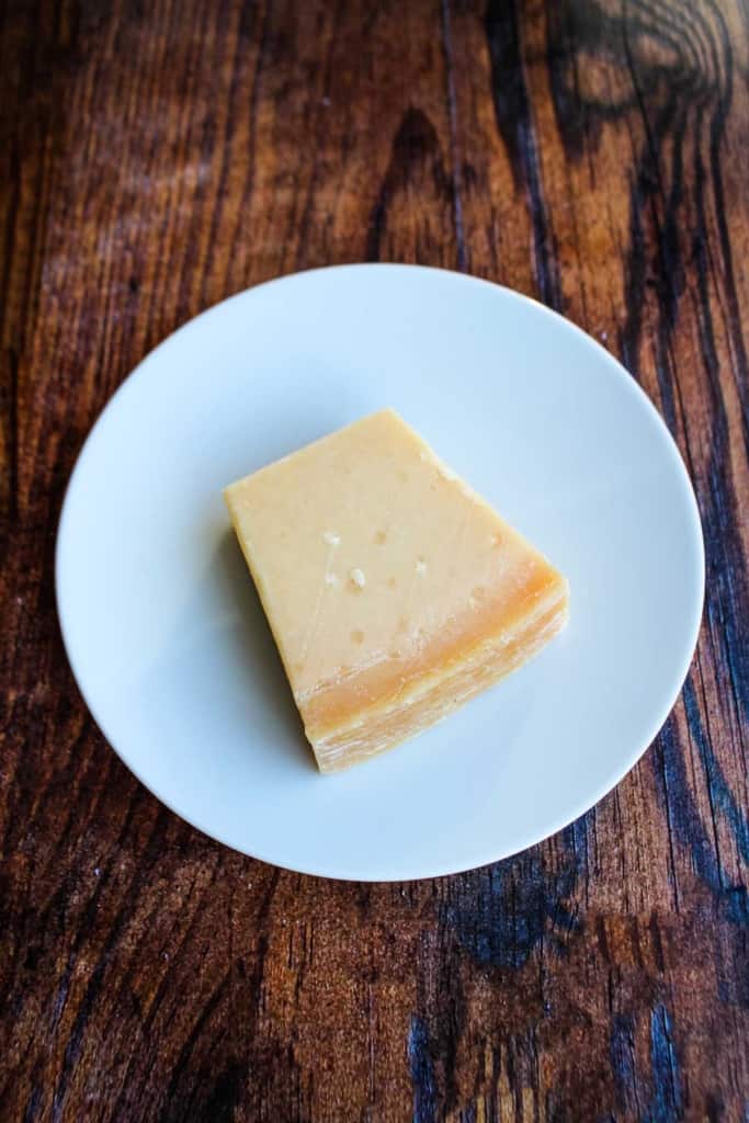 A wedge of parmesan cheese on a plate.