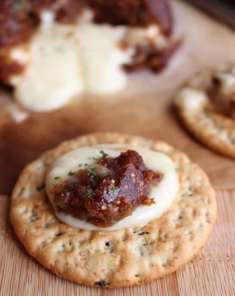 a dollop of creamy brie with fig on top of a cracker