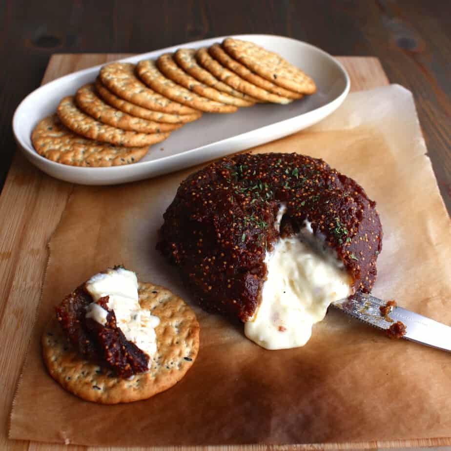 2 Ingredient Fig Baked Brie cut open and slathered on a cracker