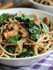 A bowl of soba noodle stir fry on the table with chopsticks.