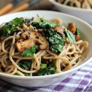 A bowl of soba noodle stir fry on the table with chopsticks.