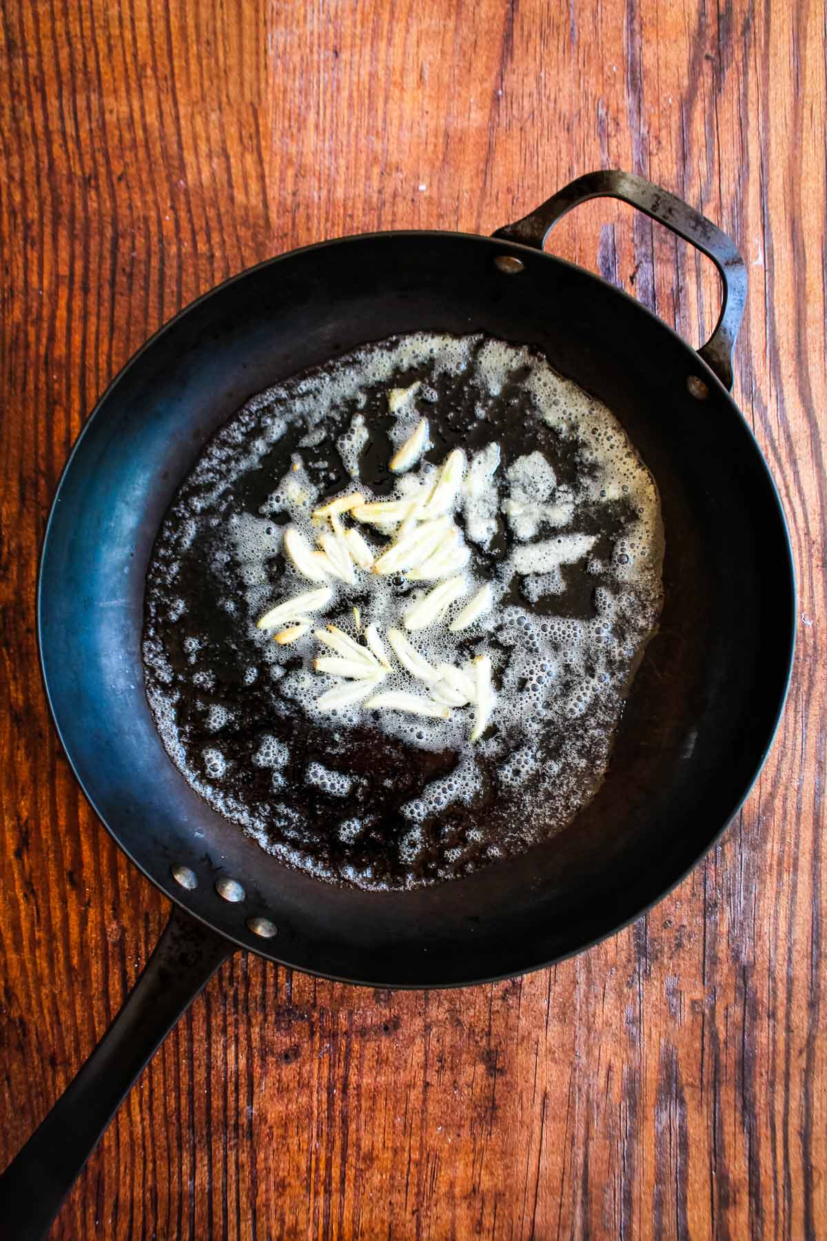 Garlic cooking in butter in a skillet.