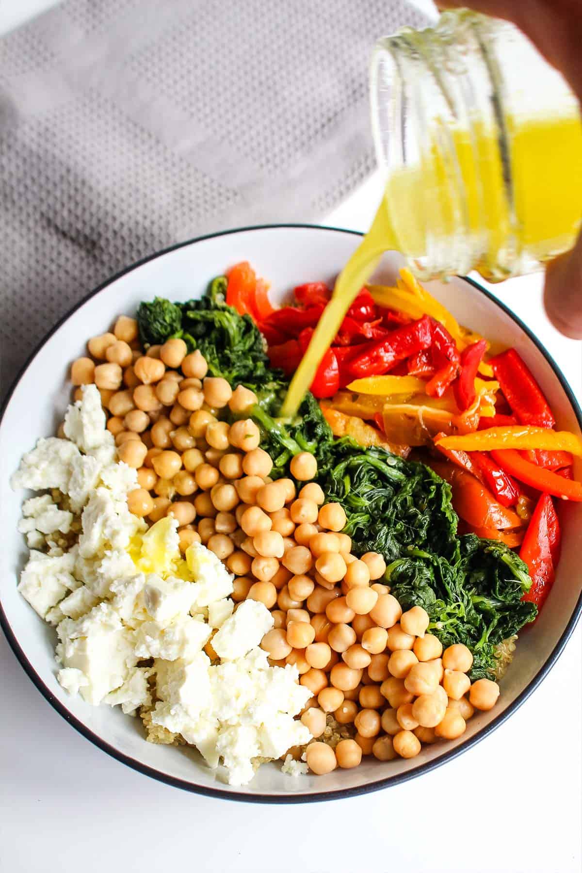 Adding the dressing to spinach couscous.