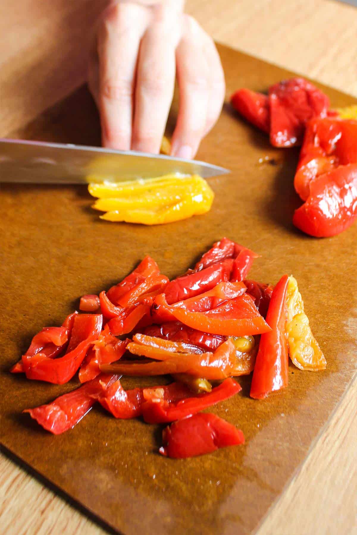 Slicing the roasted red peppers to make a spinach couscous bowl.