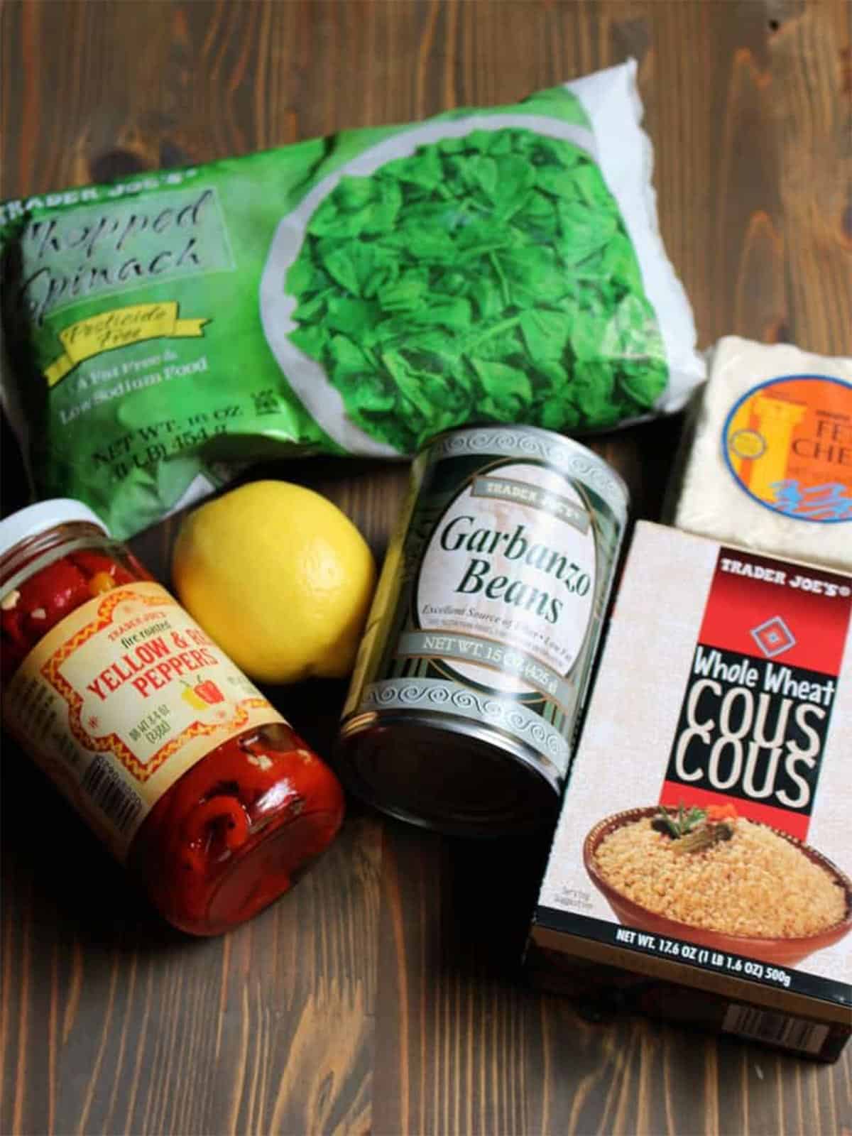 Ingredients to make spinach couscous with lemon on the table.