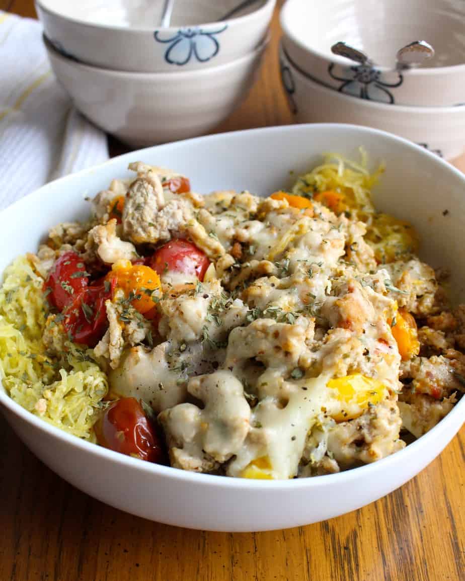 Turkey and pesto spaghetti squash with tomatoes in a white bowl