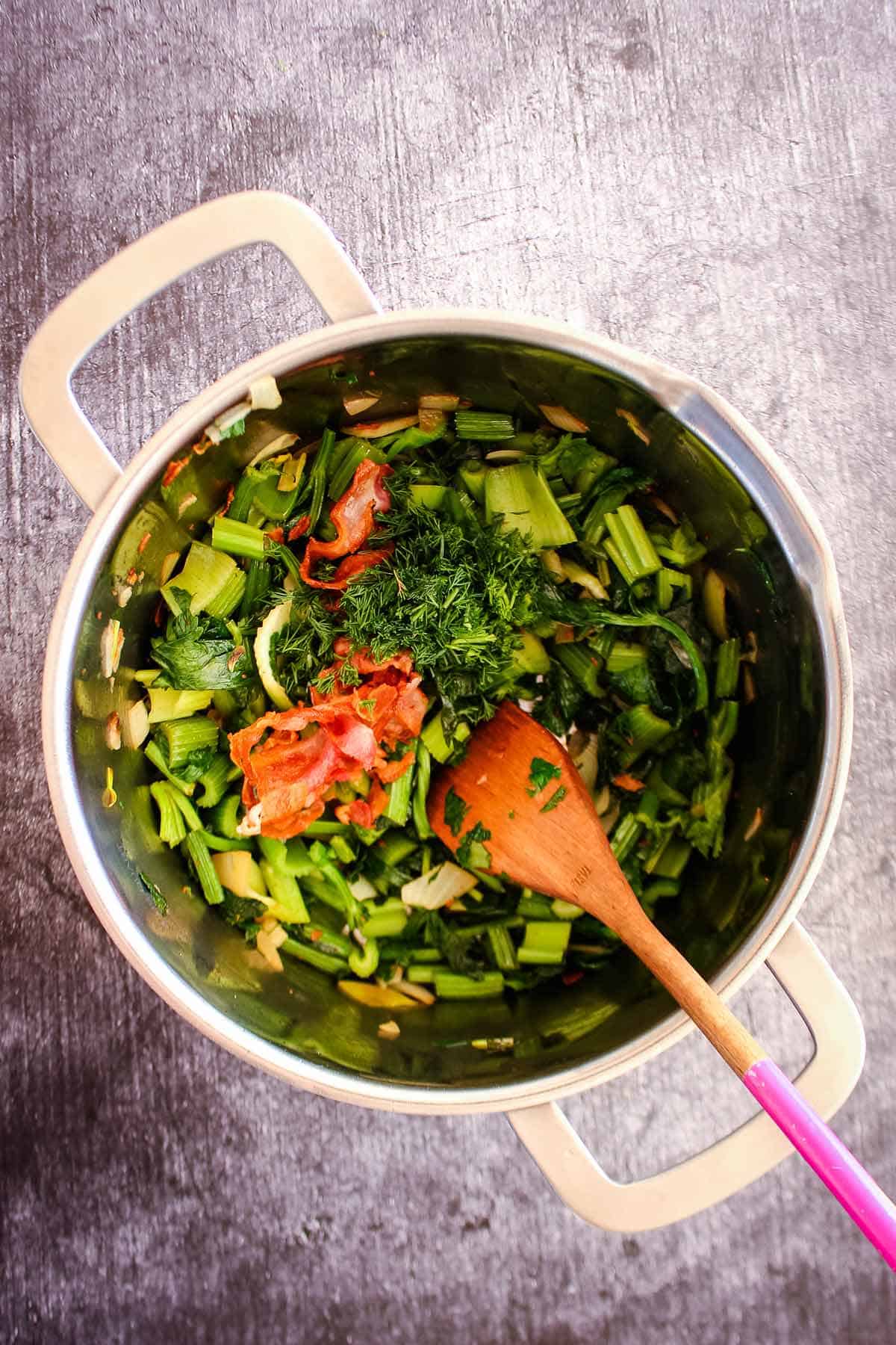 Veggies to make creamy celery soup cooked in a pot.