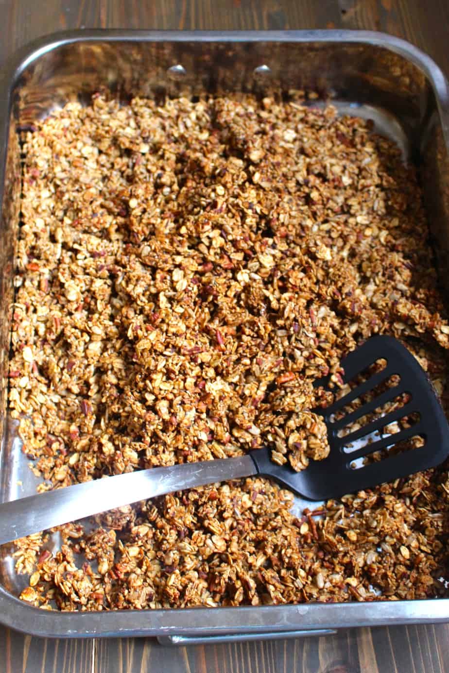 freshly homemade healthy granola with a spatula in the pan