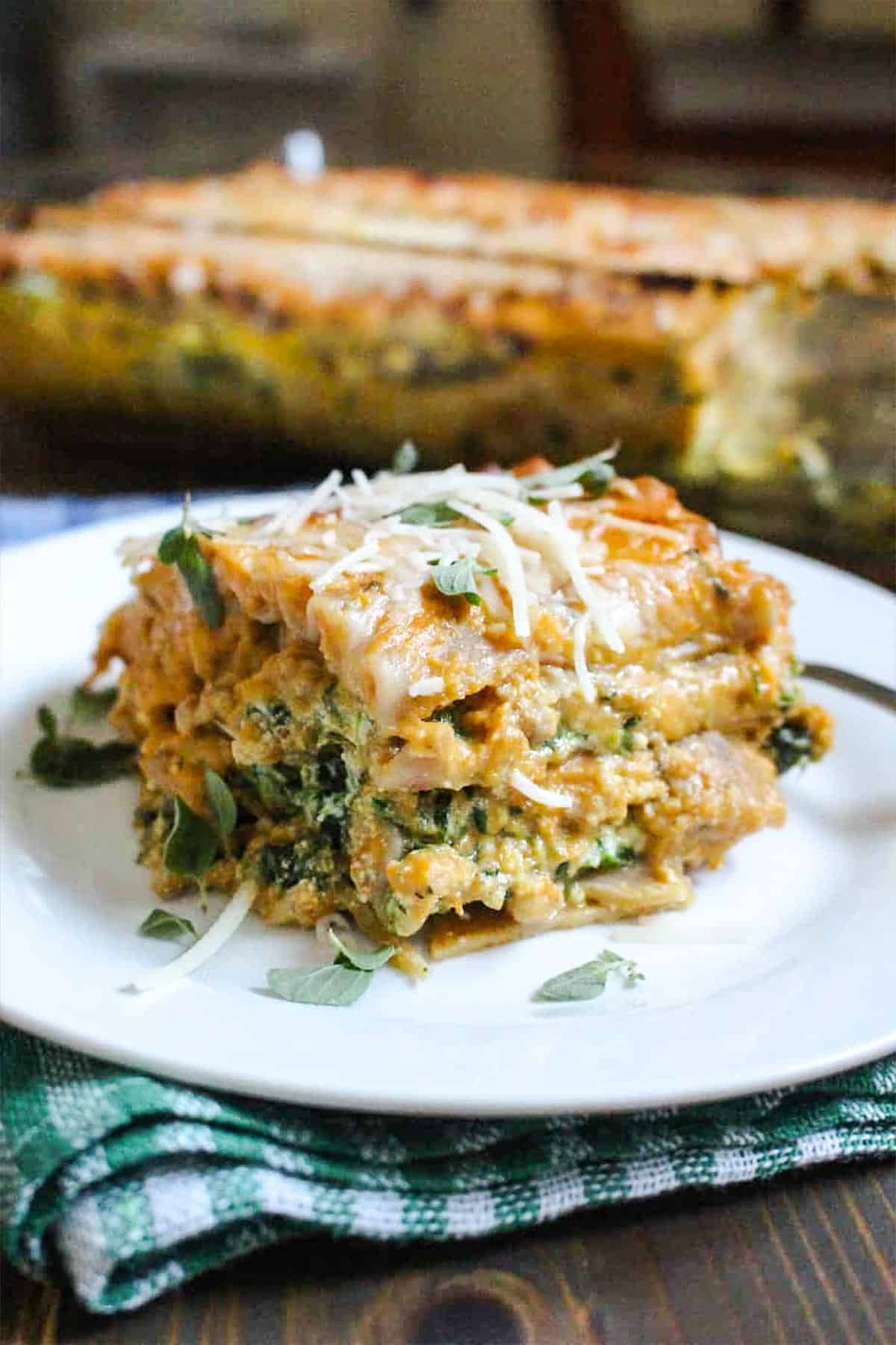 Pumpkin and spinach lasagna on a white plate.