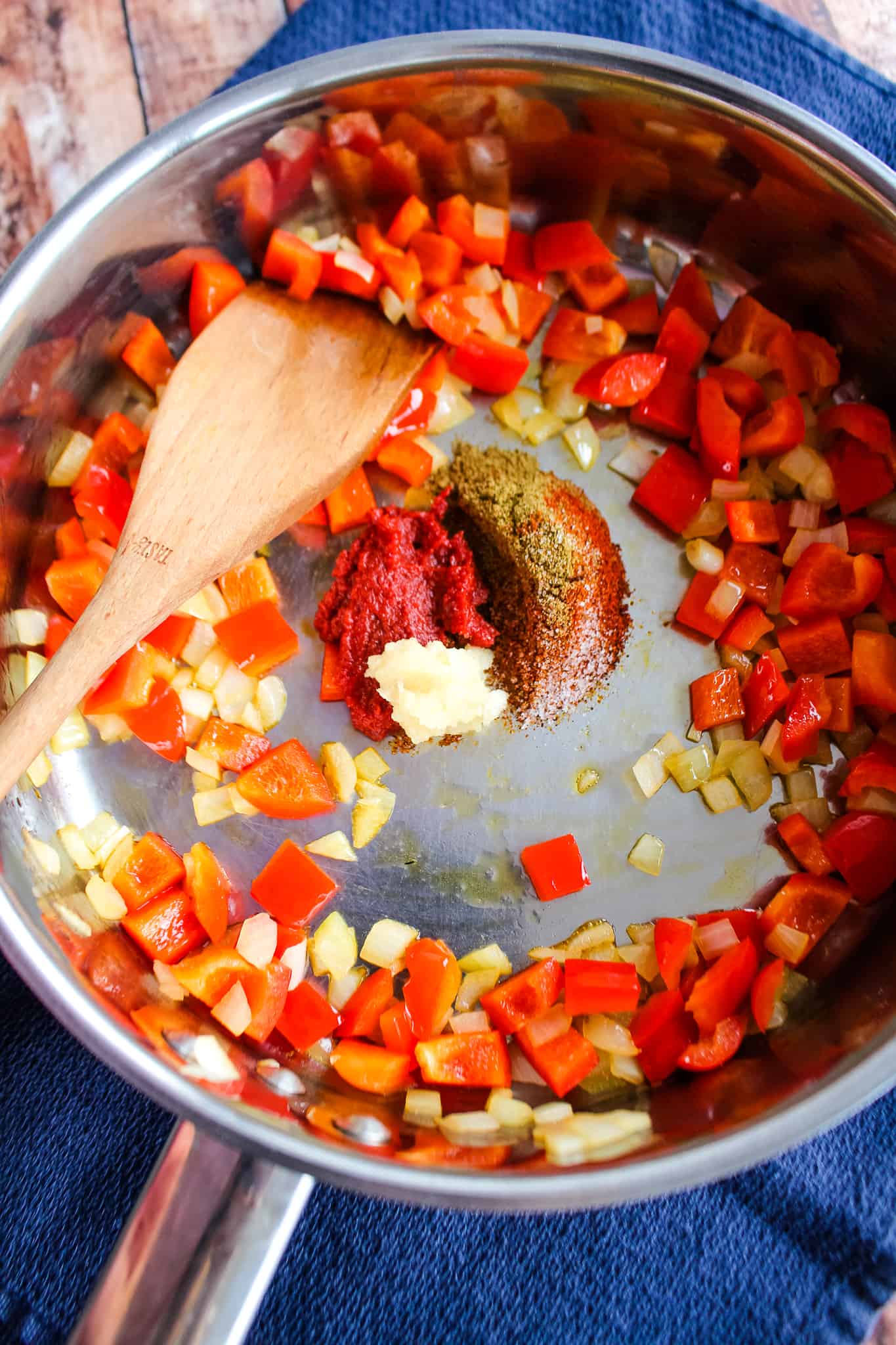 Sautéed onions and red peppers with tomato paste, garlic, and seasonings added to the pan. 