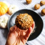 a hand holding a pumpkin spice muffin