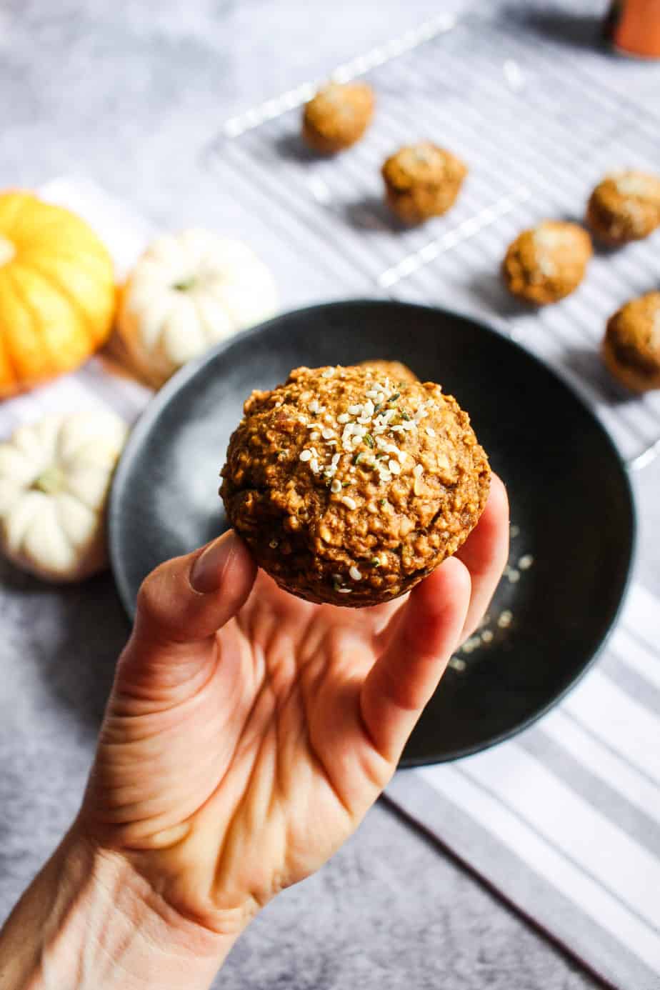 a hand holding a pumpkin spice muffin