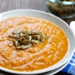 A bowl of creamy carrot soup on the table.