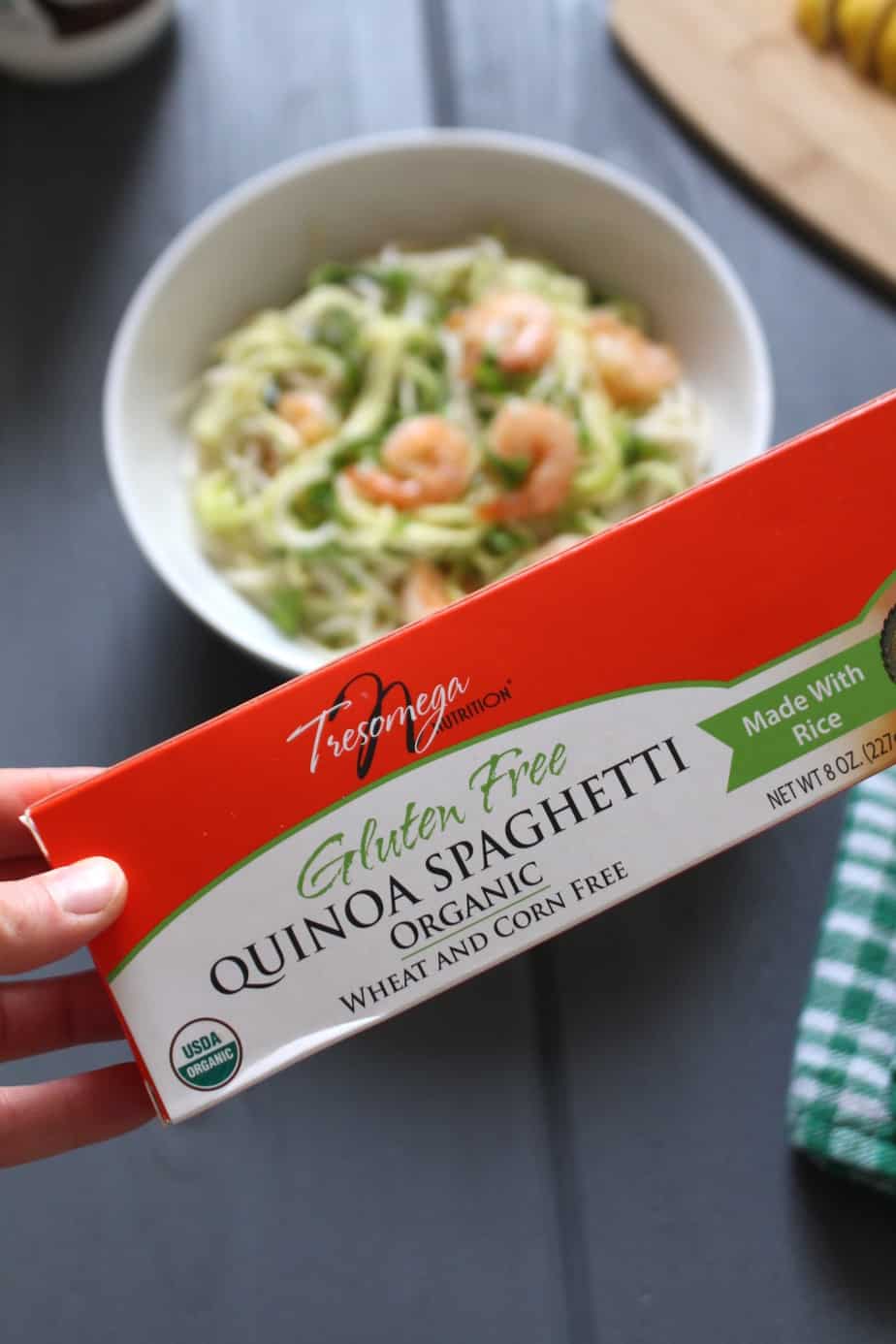 TresOmega Gluten-free Spaghetti held in front of a bowl of coconut garlic shrimp with pasta