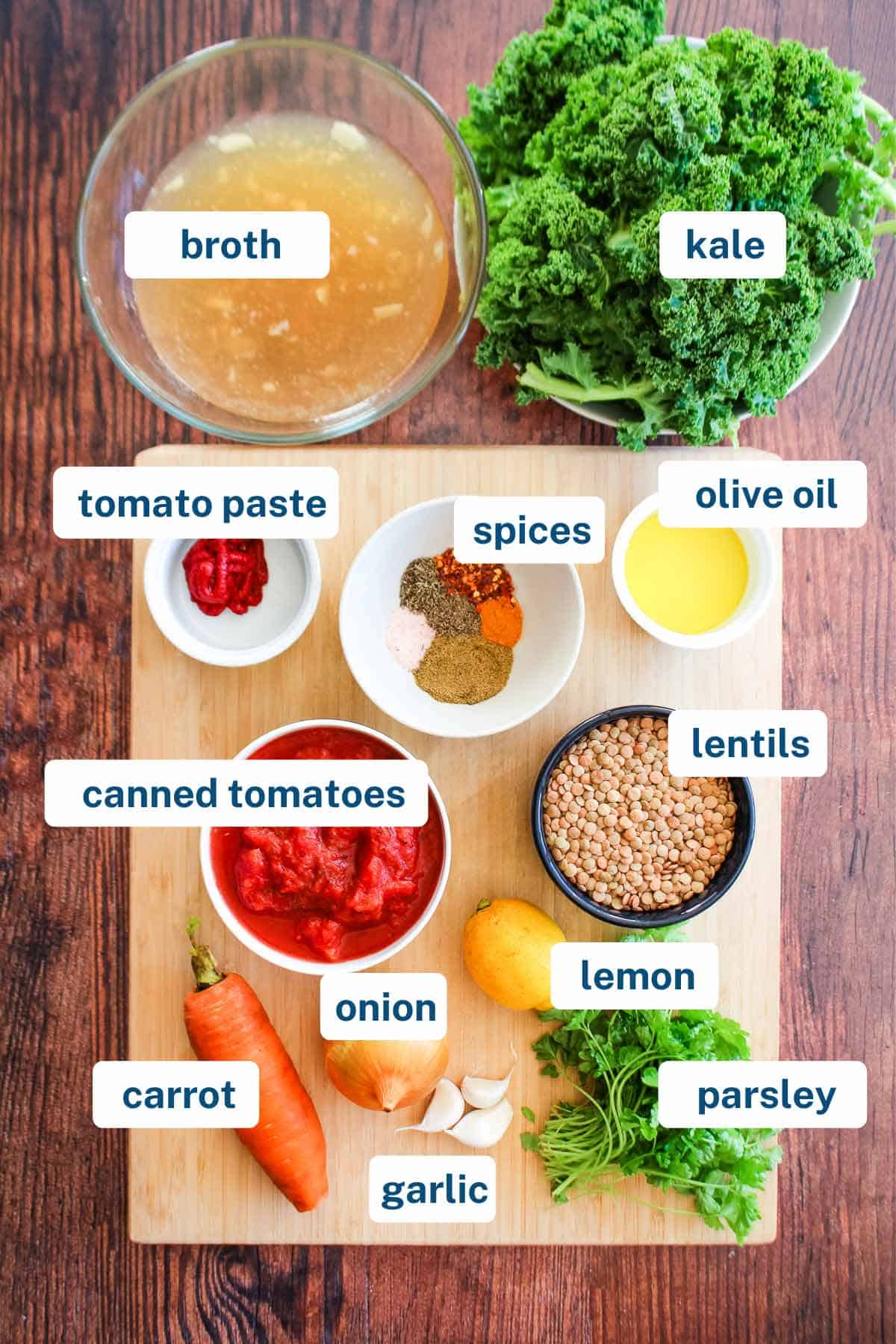 Ingredients to make lentil kale soup on the table with text labels.