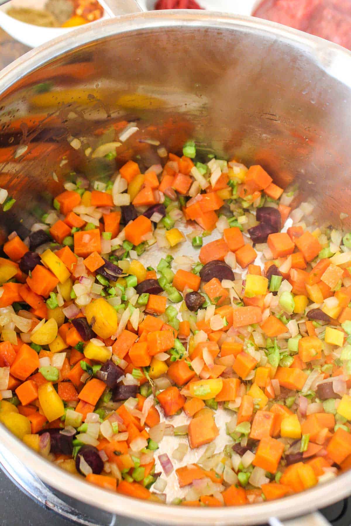 Vegetables cooking in a pot to make lentil kale soup.