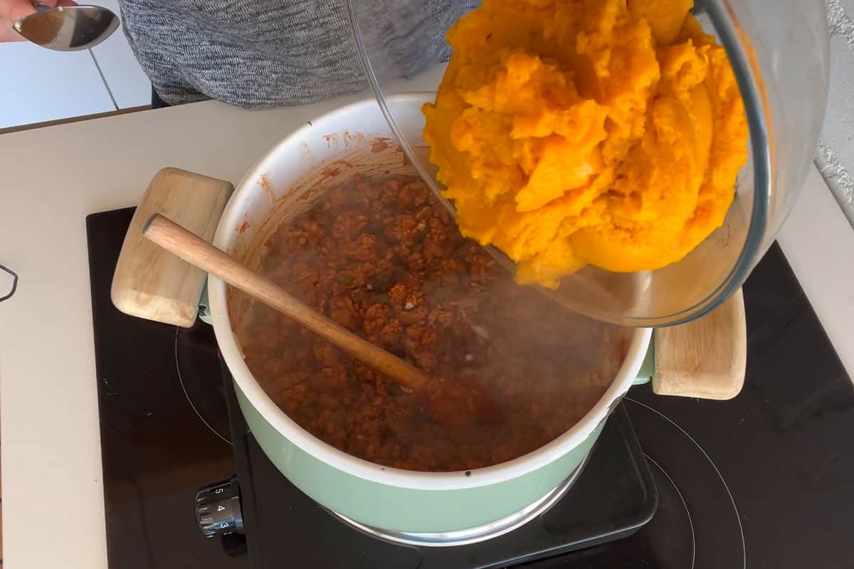 Add pumpkin to the pot of cooked meat.