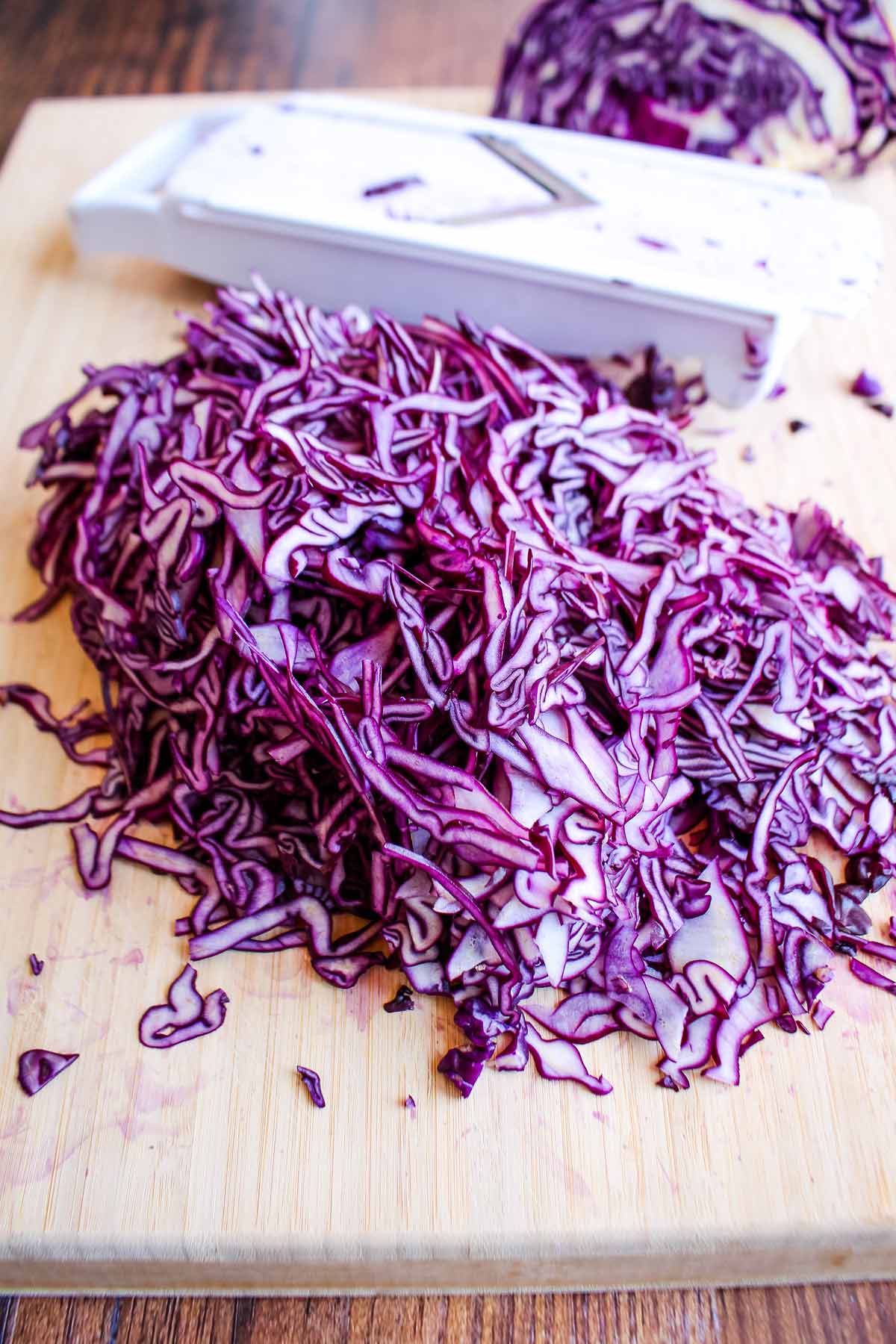 Shredded red cabbage on a cutting board.