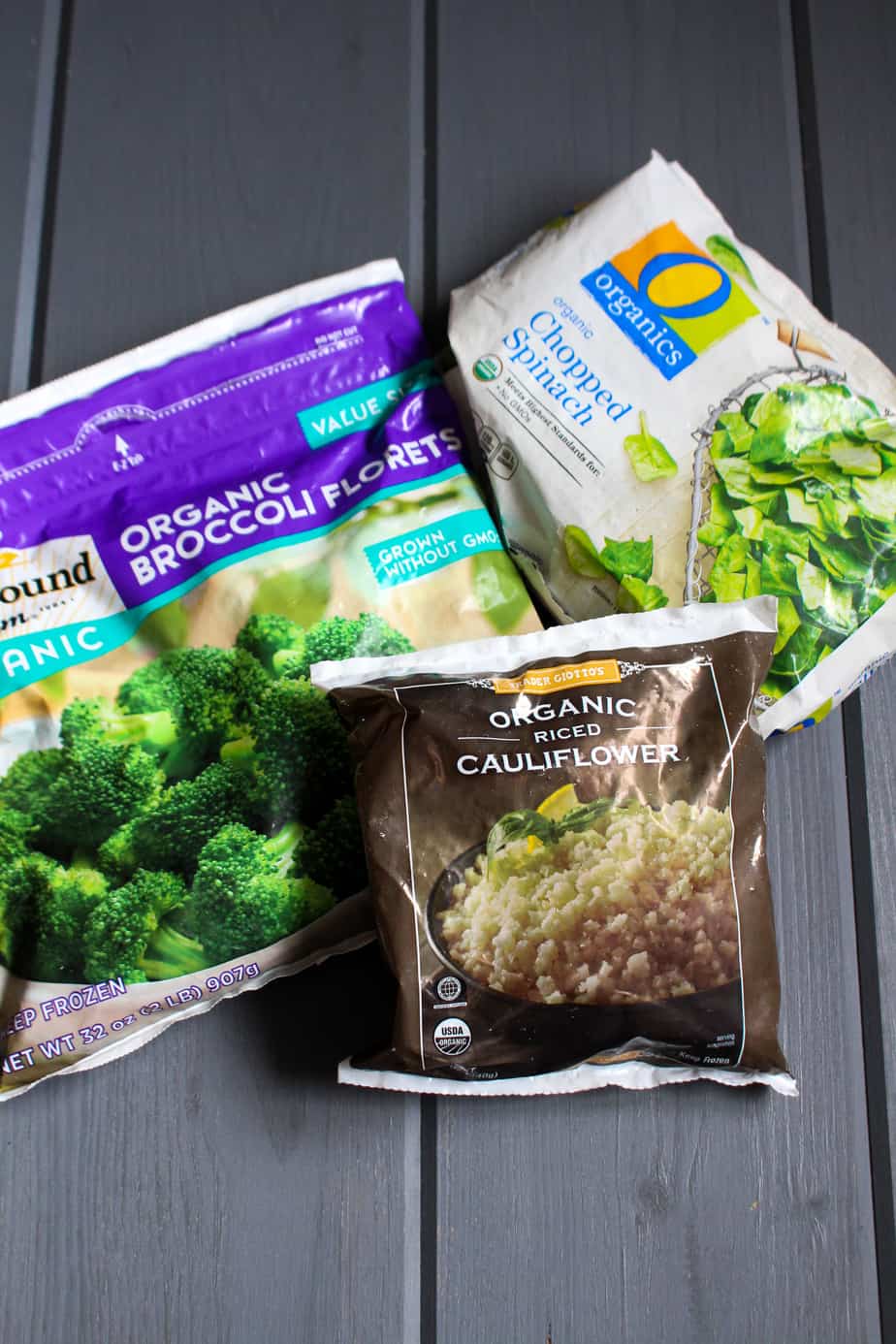 Three packages of frozen broccoli, rice cauliflower, and chopped spinach.