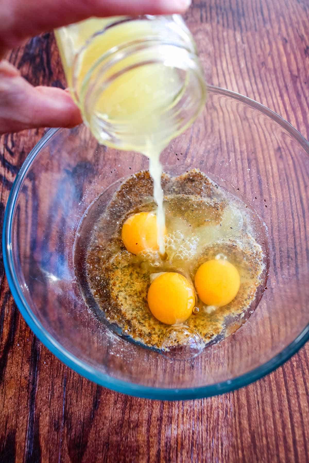 Adding the egg and lemon juice to the mixing bowl.