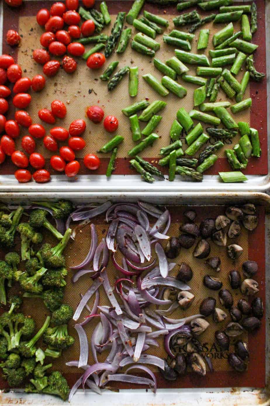 tomatoes, asparagus, broccoli, onion, and mushrooms roasted on baking sheets