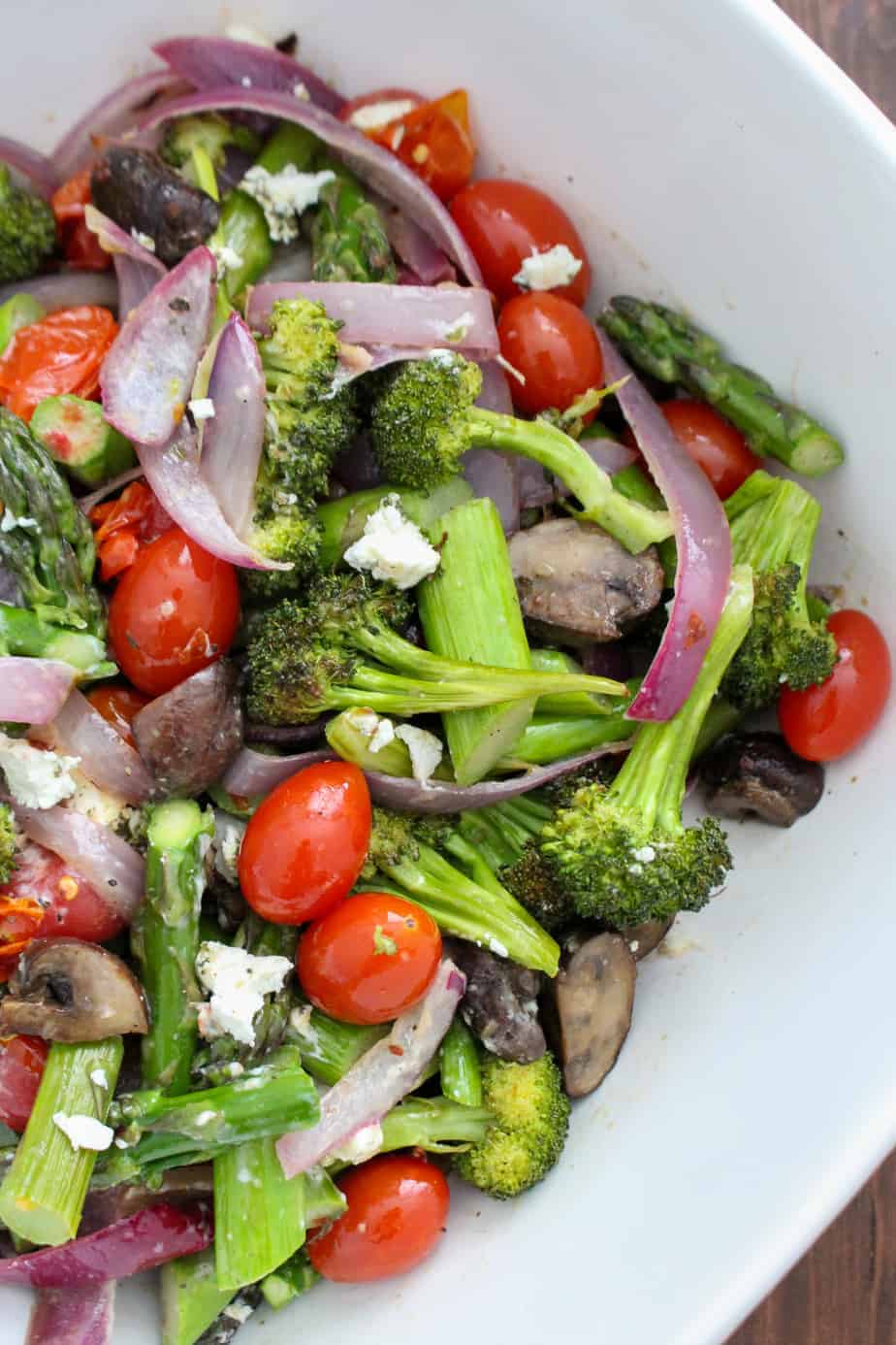 roasted broccoli, onion, tomatoes, asparagus, and mushrooms topped with crumbles of goat cheese in a bowl