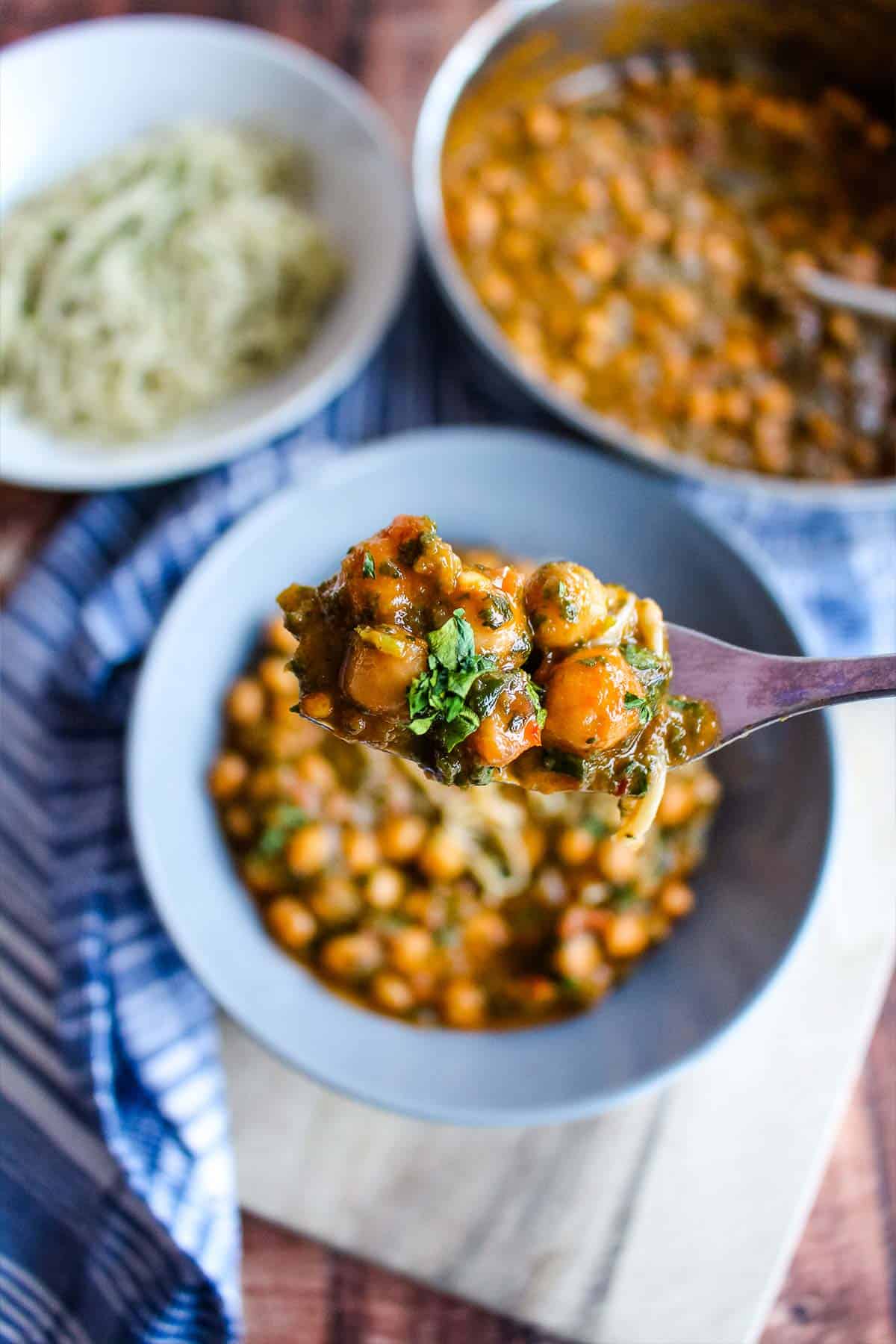 A forkful of 4-ingredient chickpeas over a bowl.