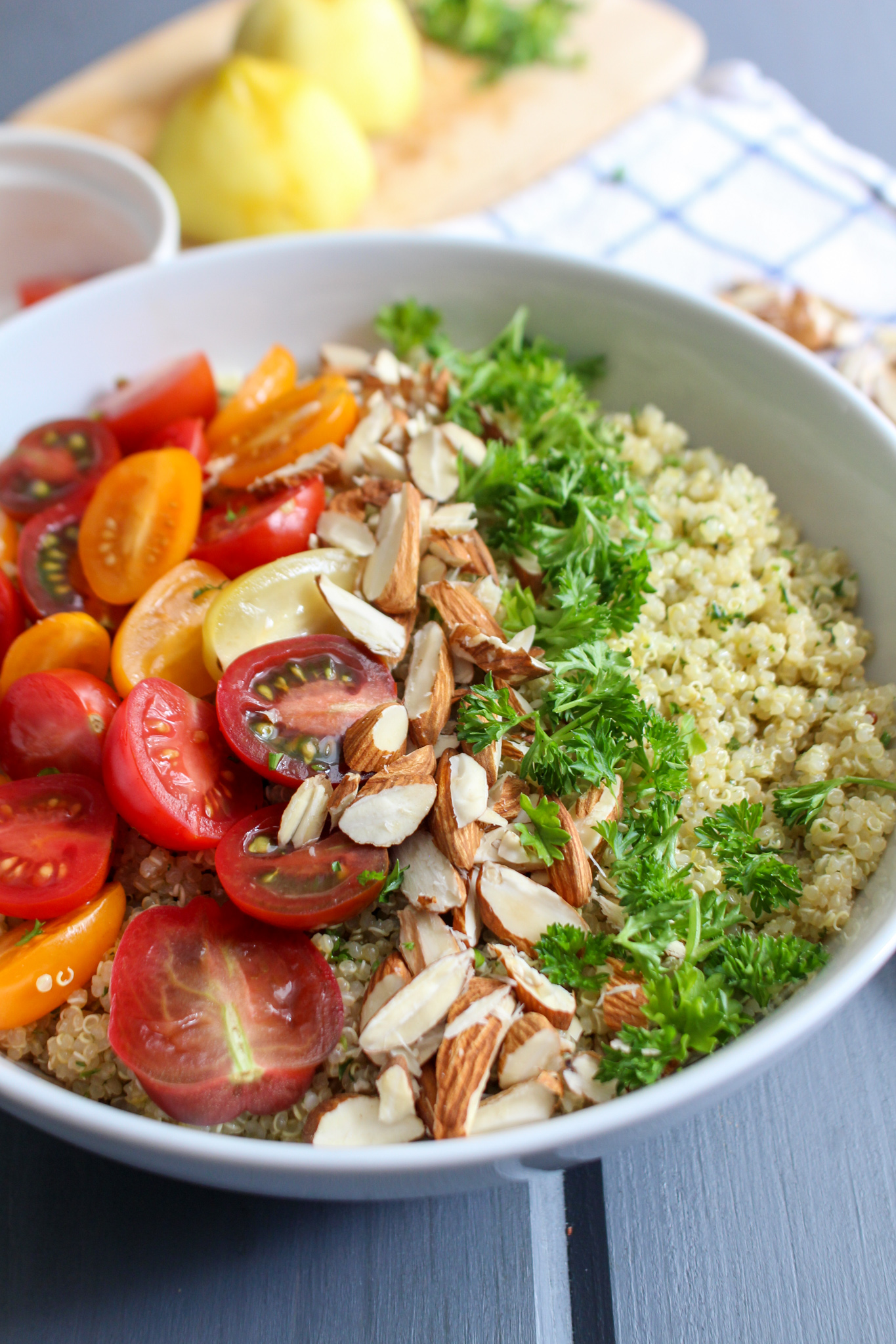 Bowl of quinoa salad with parsley, almonds, and tricolor grape tomatoes